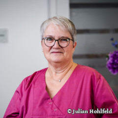 Profilbild einer freundlich lächelnden medizinischen Mitarbeiterin 